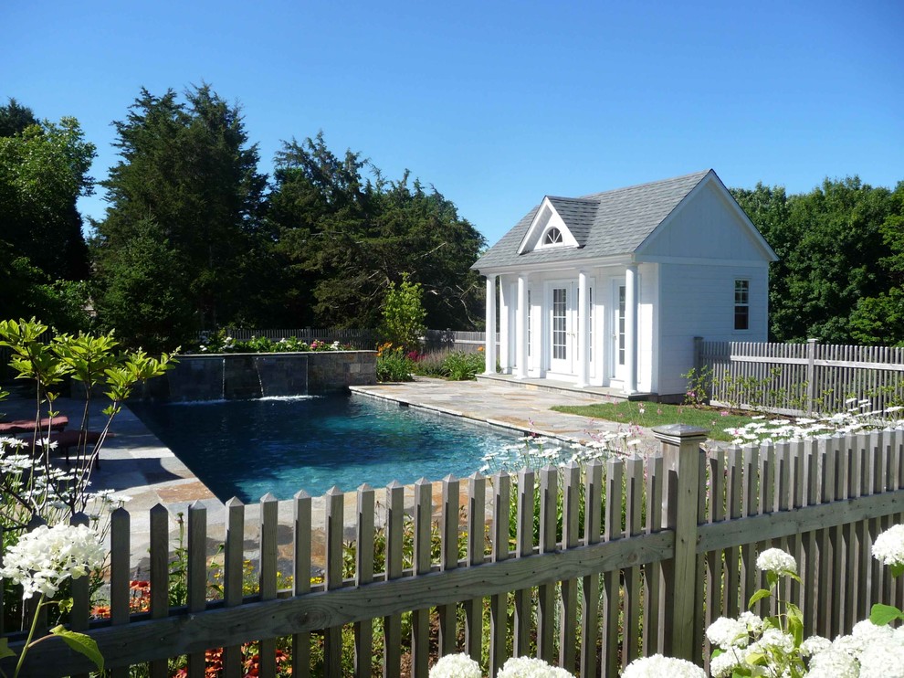 Modelo de casa de la piscina y piscina alargada clásica rectangular en patio trasero con adoquines de piedra natural