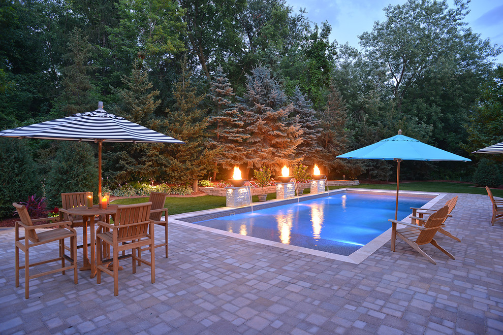 Inspiration for a large rustic back rectangular swimming pool in Minneapolis with concrete paving.