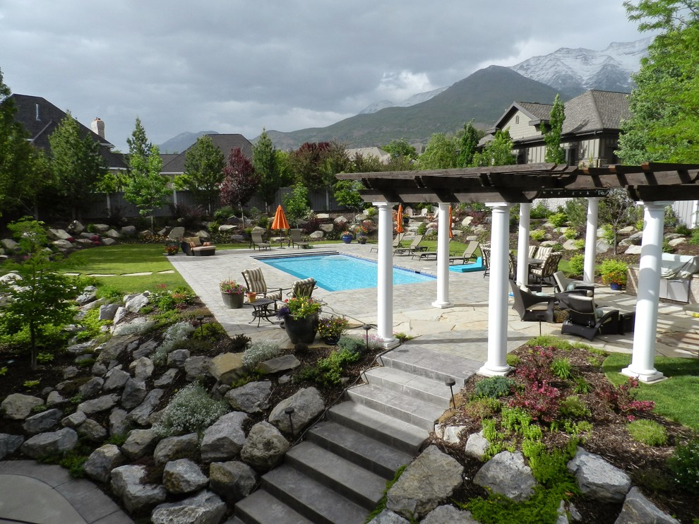Modelo de piscina clásica renovada rectangular en patio trasero con paisajismo de piscina