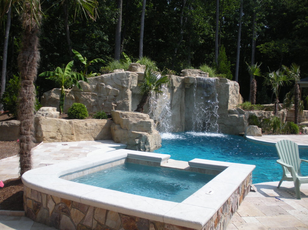 Photo of a large traditional back custom shaped hot tub in Raleigh with natural stone paving.