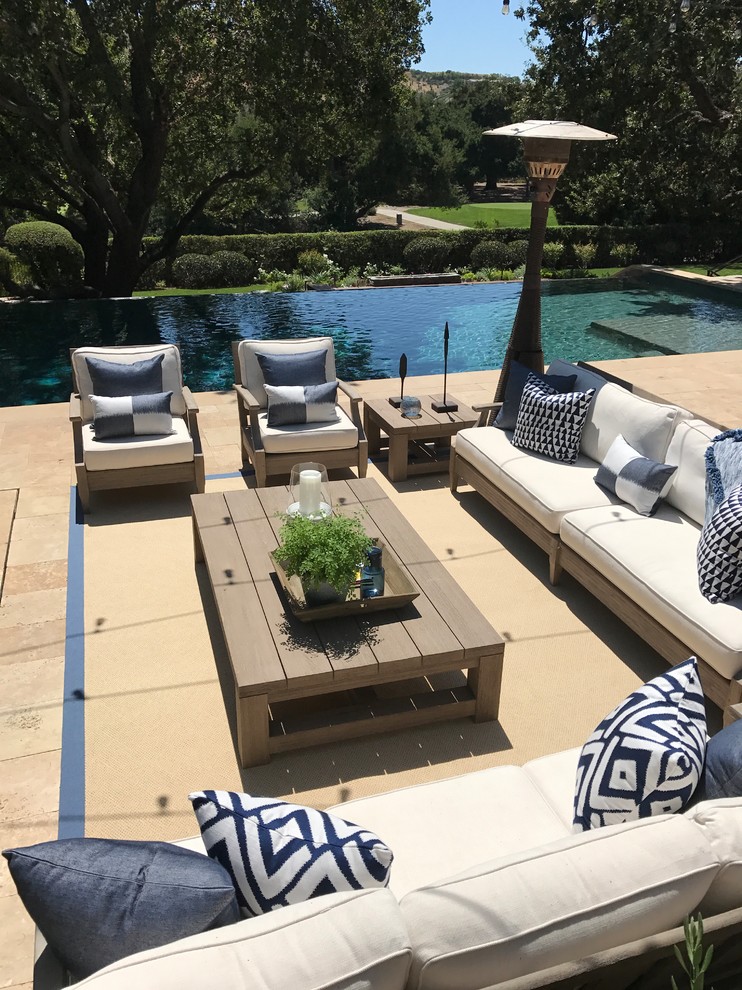 Foto de piscina infinita de estilo americano grande rectangular en patio trasero con adoquines de piedra natural