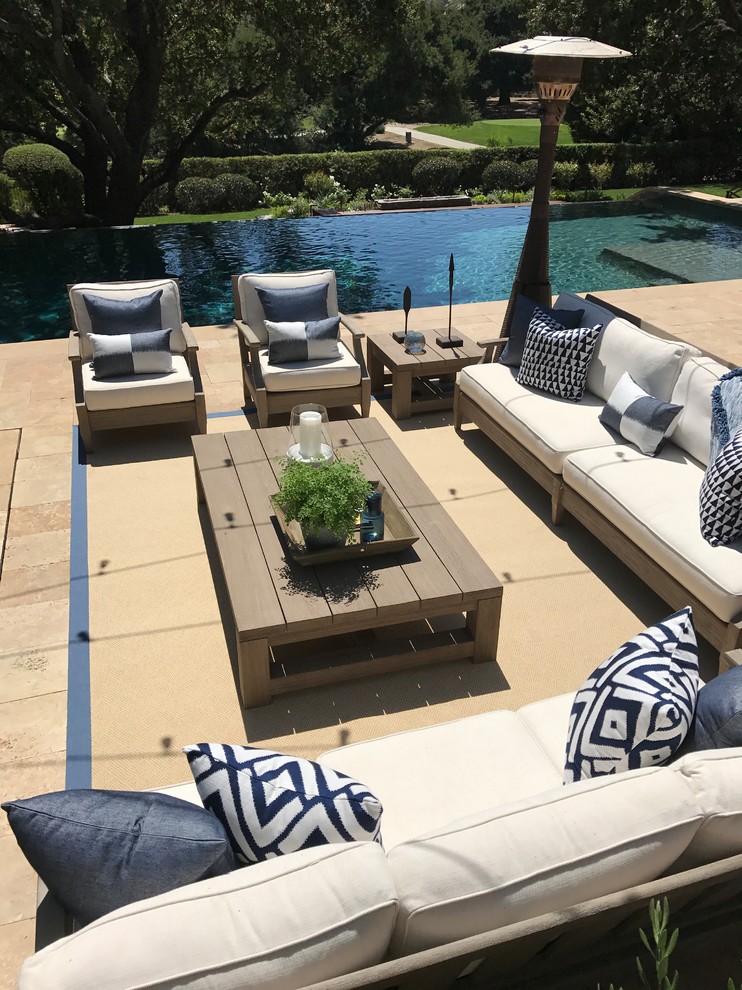 Modelo de piscina infinita de estilo americano grande rectangular en patio trasero con adoquines de piedra natural