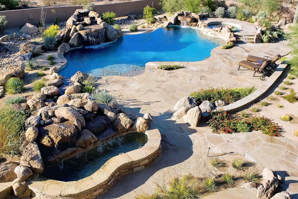 Exemple d'une grande piscine à débordement et arrière sud-ouest américain sur mesure avec un bain bouillonnant et une dalle de béton.