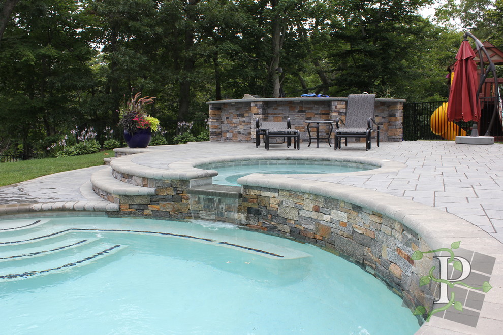 Inredning av en klassisk stor anpassad pool på baksidan av huset, med spabad och marksten i betong