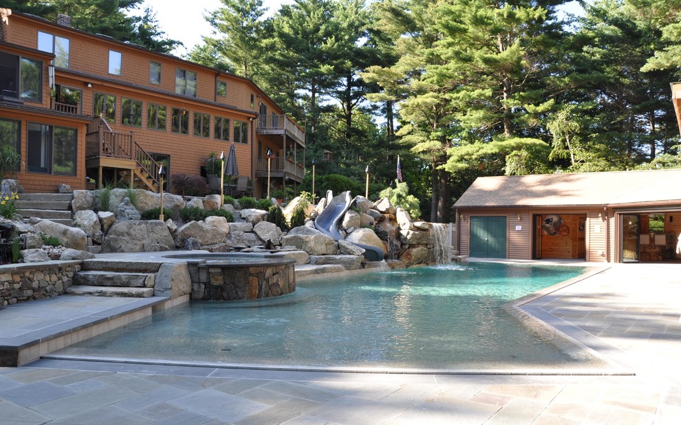 Ejemplo de piscina con tobogán natural costera extra grande a medida en patio trasero con adoquines de piedra natural