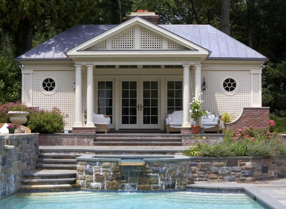 Classic back rectangular swimming pool in New York with a pool house.