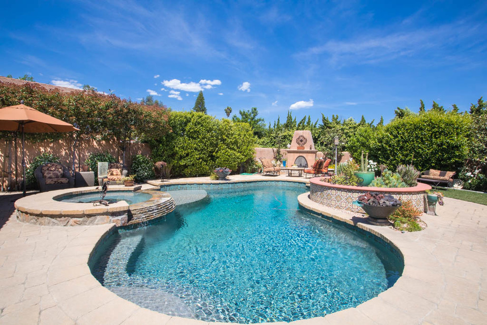 Großer Mediterraner Whirlpool hinter dem Haus in individueller Form mit Natursteinplatten in Los Angeles