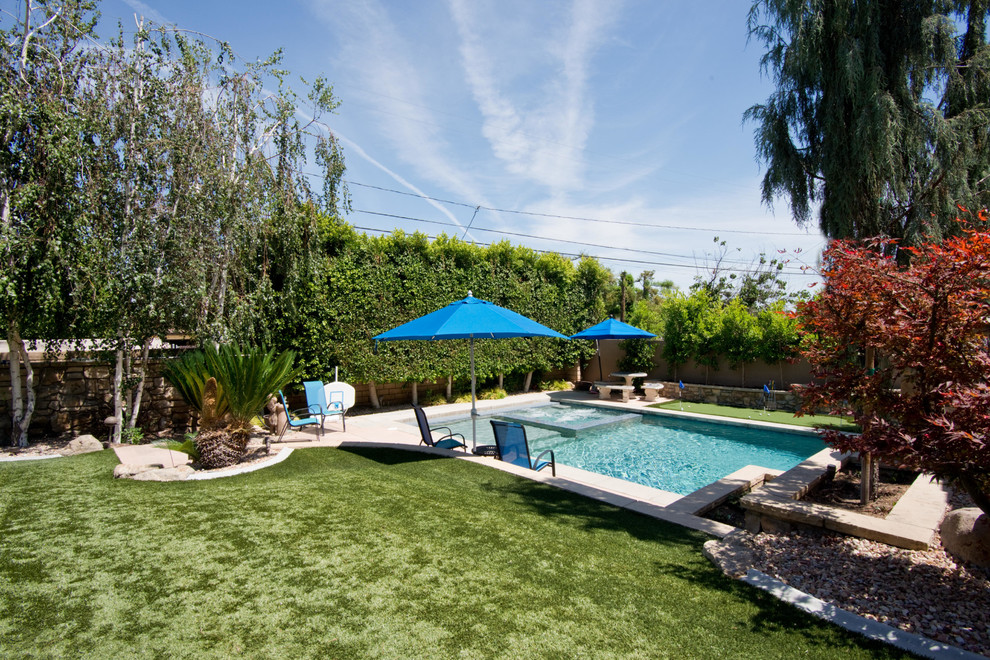 Пример оригинального дизайна: большой спортивный, прямоугольный бассейн на заднем дворе в стиле модернизм с джакузи и покрытием из бетонных плит