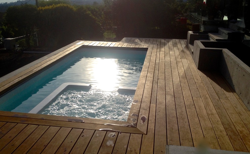Réalisation d'une petite piscine naturelle et arrière design rectangle avec un bain bouillonnant et une terrasse en bois.