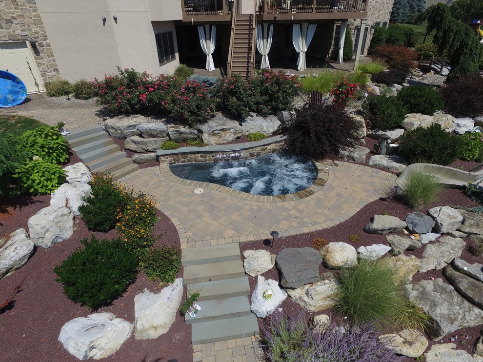 Idee per una piscina naturale tradizionale personalizzata dietro casa con un acquascivolo e pavimentazioni in mattoni