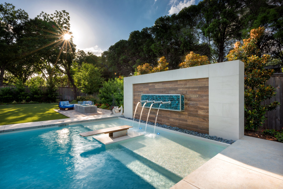Idee per una grande piscina minimalista rettangolare dietro casa con pedane