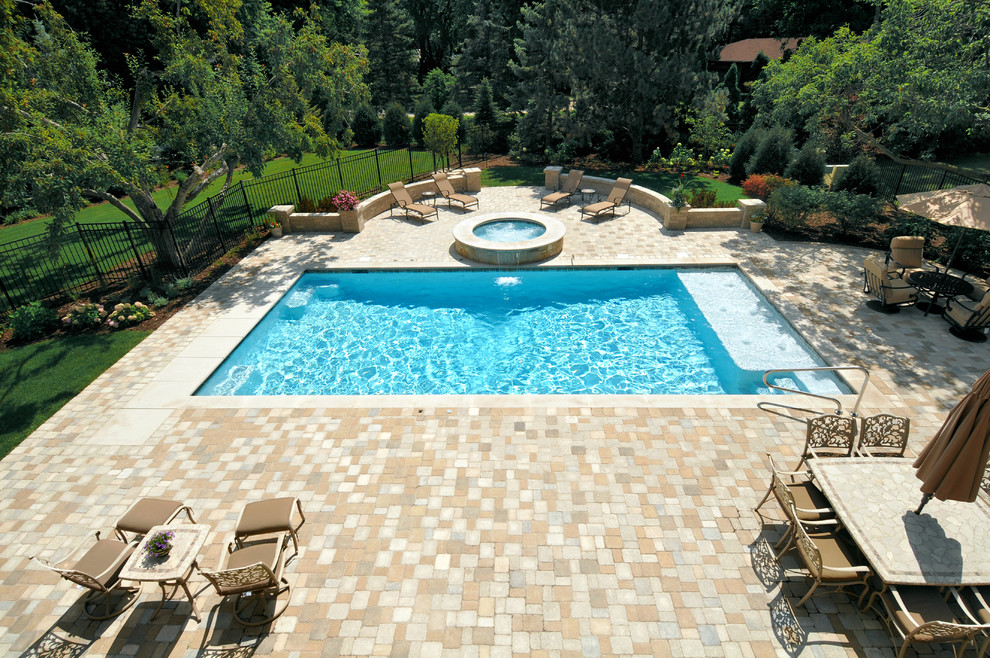 Imagen de piscinas y jacuzzis alargados clásicos pequeños rectangulares en patio trasero con adoquines de hormigón