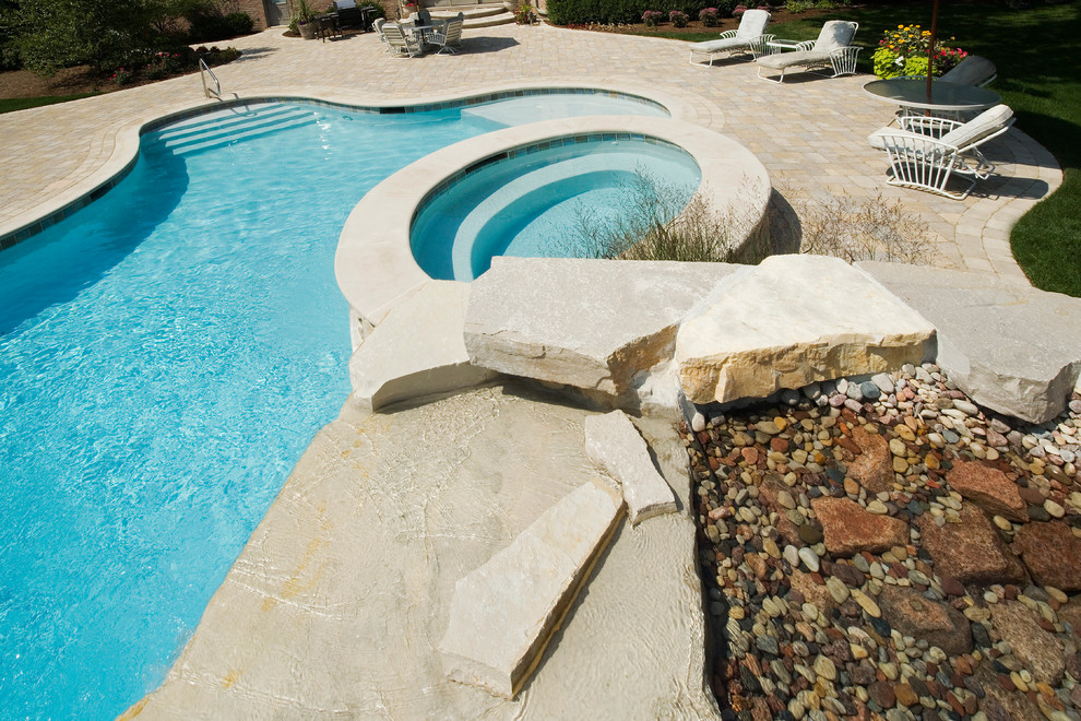Стильный дизайн: огромный естественный бассейн произвольной формы на заднем дворе в стиле рустика с водной горкой и мощением тротуарной плиткой - последний тренд