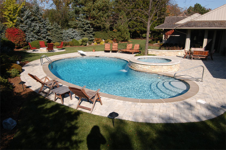 Diseño de piscinas y jacuzzis naturales tradicionales pequeños a medida en patio trasero con adoquines de hormigón