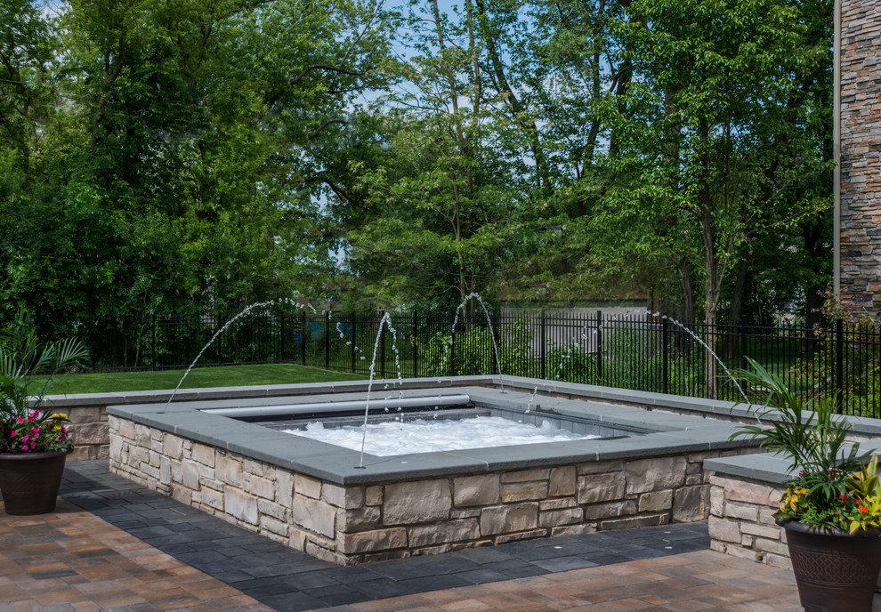 Imagen de piscinas y jacuzzis naturales clásicos pequeños rectangulares en patio trasero con adoquines de hormigón