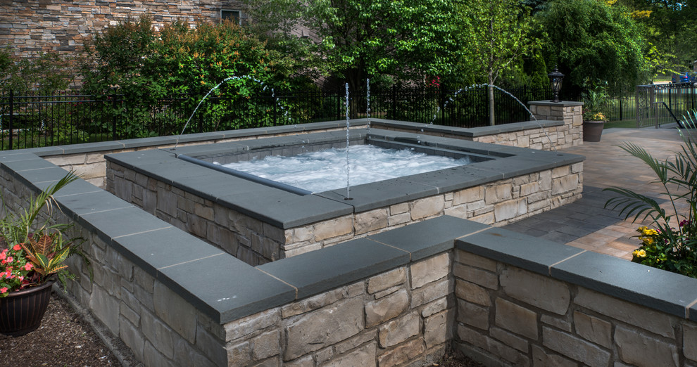 Esempio di una piccola piscina naturale chic rettangolare dietro casa con una vasca idromassaggio e pavimentazioni in cemento