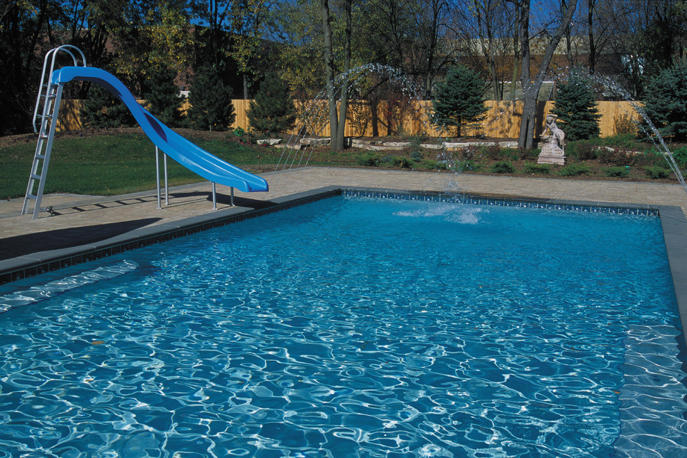 Imagen de piscinas y jacuzzis alargados clásicos de tamaño medio rectangulares en patio trasero con adoquines de hormigón