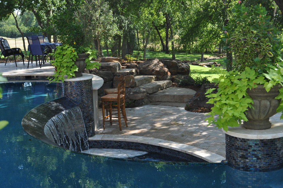 Ispirazione per una grande piscina eclettica personalizzata dietro casa con pavimentazioni in pietra naturale
