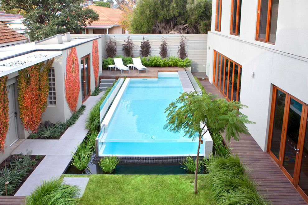 Large modern courtyard rectangular lengths swimming pool in Melbourne with decking.