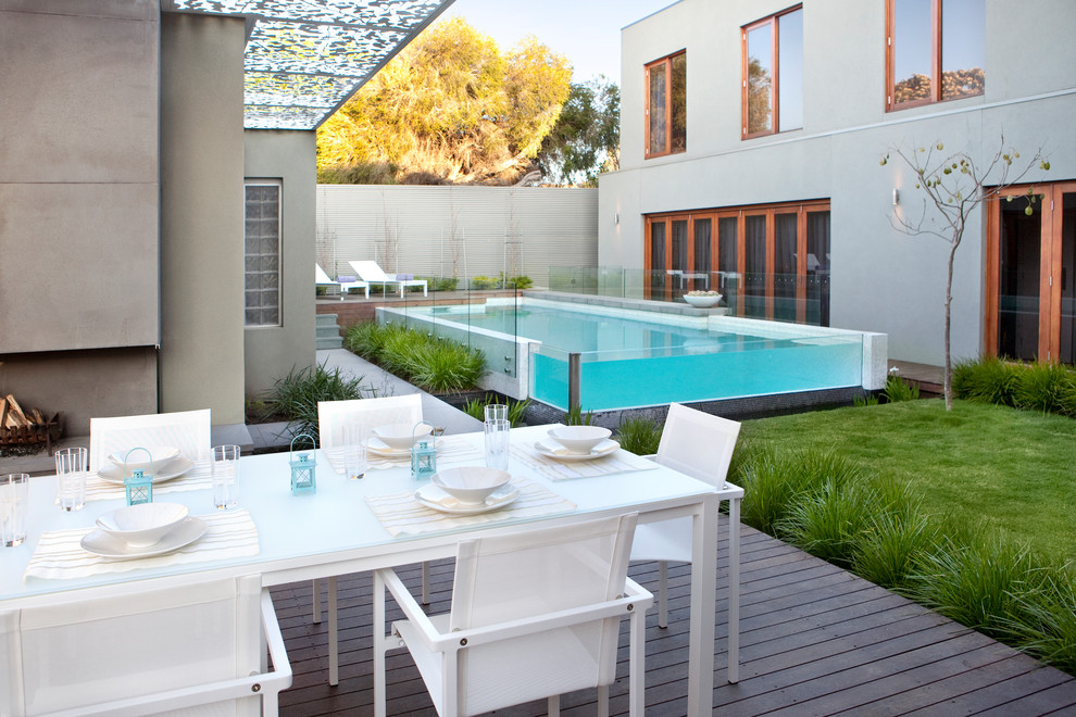 Imagen de piscina alargada minimalista grande rectangular en patio con entablado