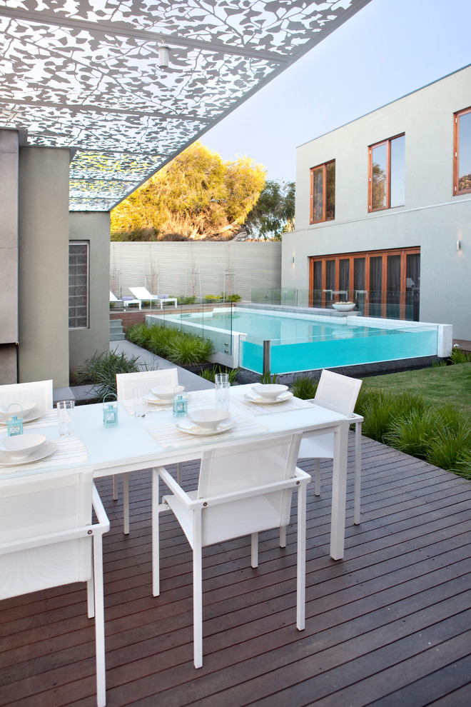 Diseño de piscina alargada moderna grande rectangular en patio con entablado