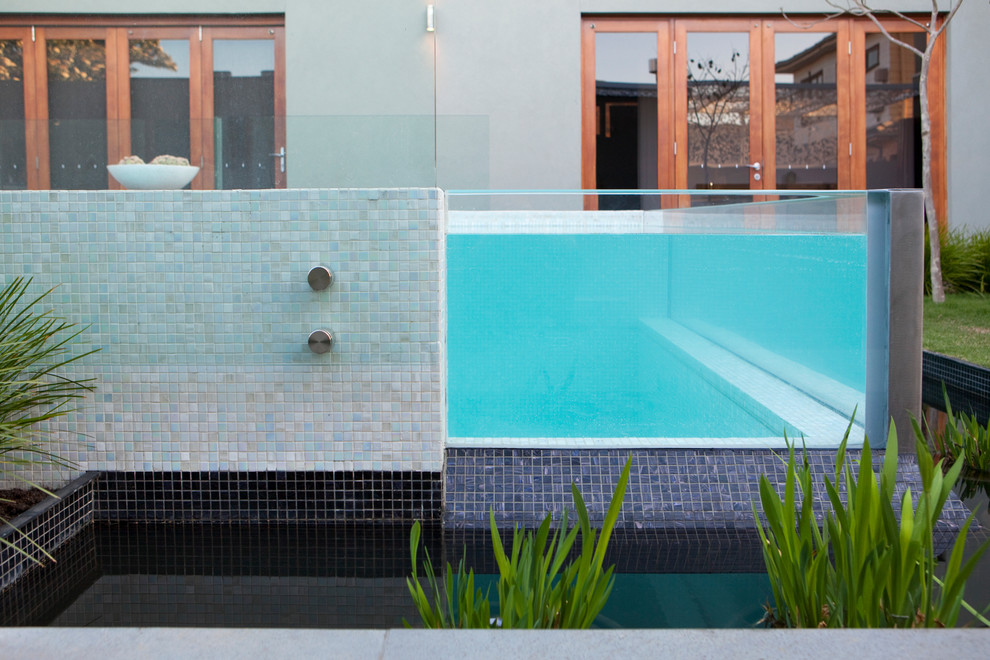 Esempio di una grande piscina monocorsia minimalista rettangolare in cortile con pedane