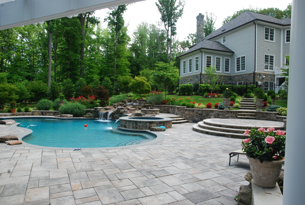 Ejemplo de piscina con fuente natural ecléctica de tamaño medio a medida en patio lateral con adoquines de hormigón