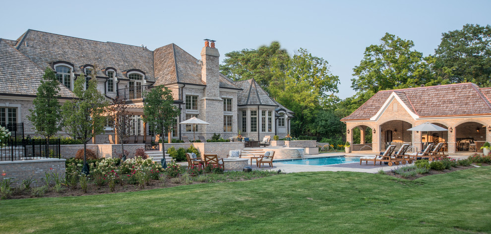 Imagen de piscinas y jacuzzis alargados clásicos de tamaño medio rectangulares en patio trasero con adoquines de hormigón