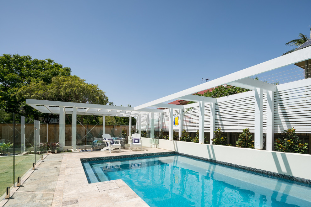 Foto di una grande piscina design rettangolare dietro casa con piastrelle