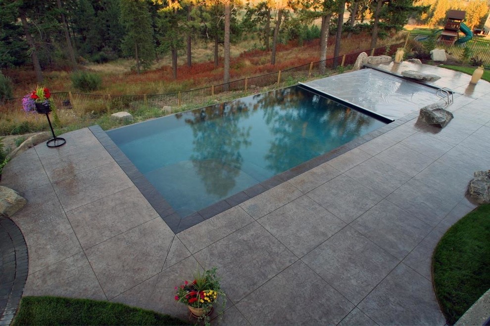 Cette image montre une piscine à débordement et arrière traditionnelle de taille moyenne et rectangle avec du béton estampé.