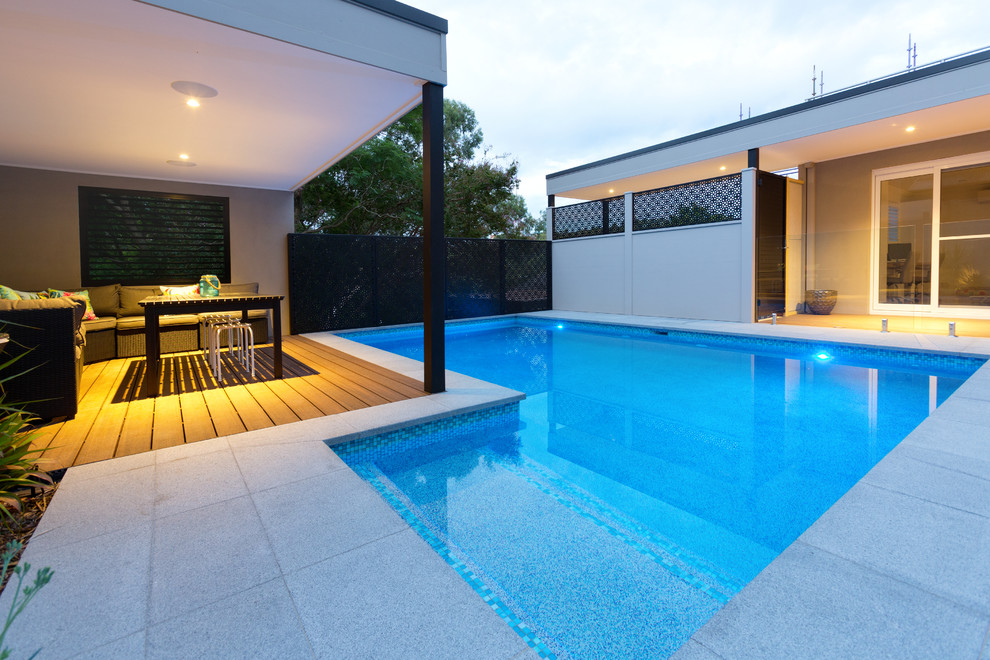 Design ideas for a large contemporary back rectangular swimming pool in Sydney with natural stone paving.