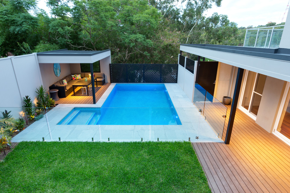 Идея дизайна: большой прямоугольный бассейн на заднем дворе в современном стиле с покрытием из каменной брусчатки