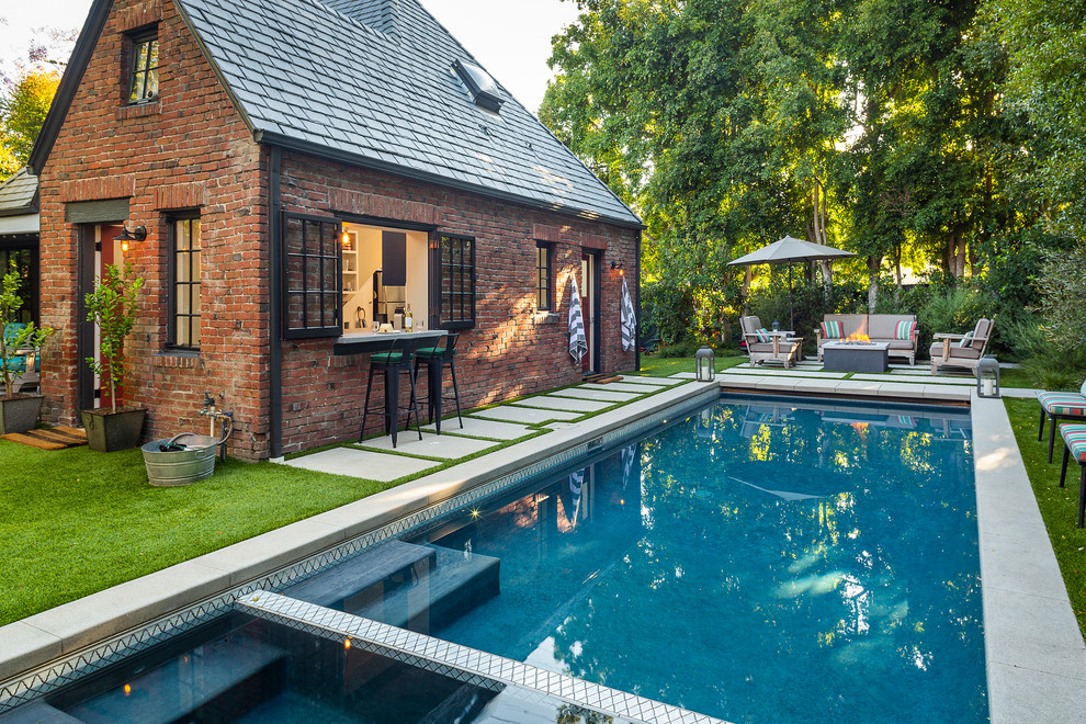 Foto de piscinas y jacuzzis alargados tradicionales renovados grandes rectangulares en patio trasero con losas de hormigón