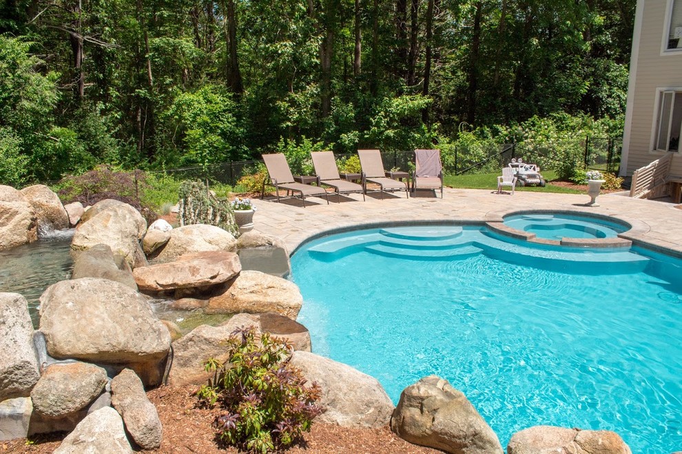 Пример оригинального дизайна: огромный естественный бассейн в форме фасоли на заднем дворе в морском стиле с джакузи и покрытием из каменной брусчатки