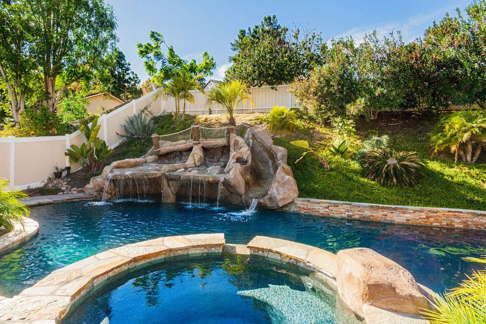 Idéer för en stor exotisk pool på baksidan av huset, med vattenrutschkana och naturstensplattor