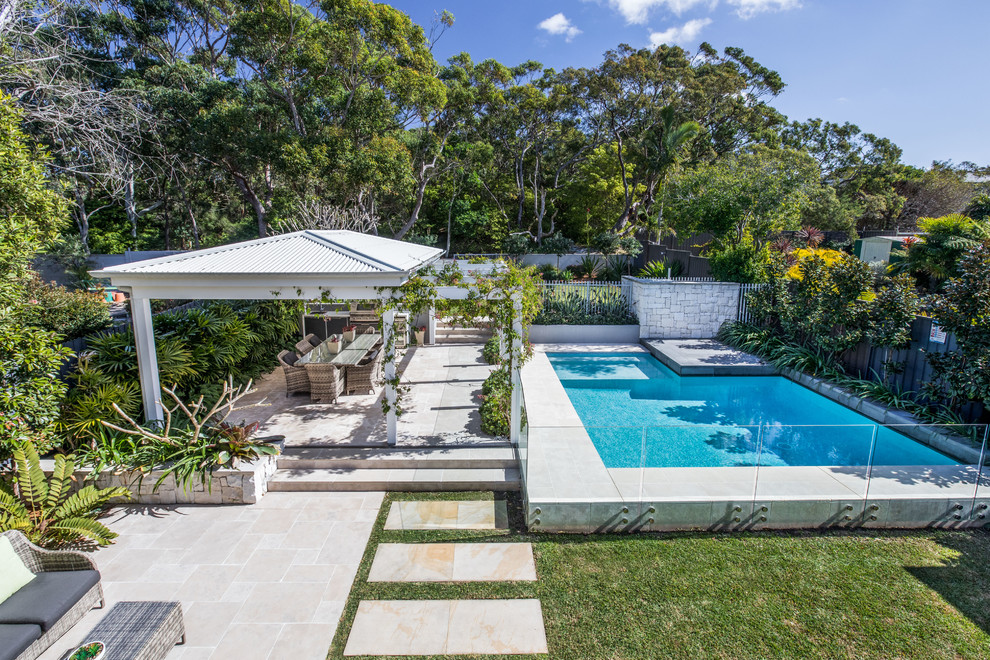 Ejemplo de piscina alargada contemporánea de tamaño medio a medida en patio trasero con adoquines de piedra natural