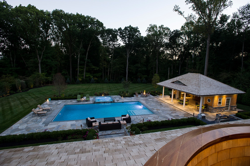 Klassischer Pool hinter dem Haus in rechteckiger Form mit Natursteinplatten in New York