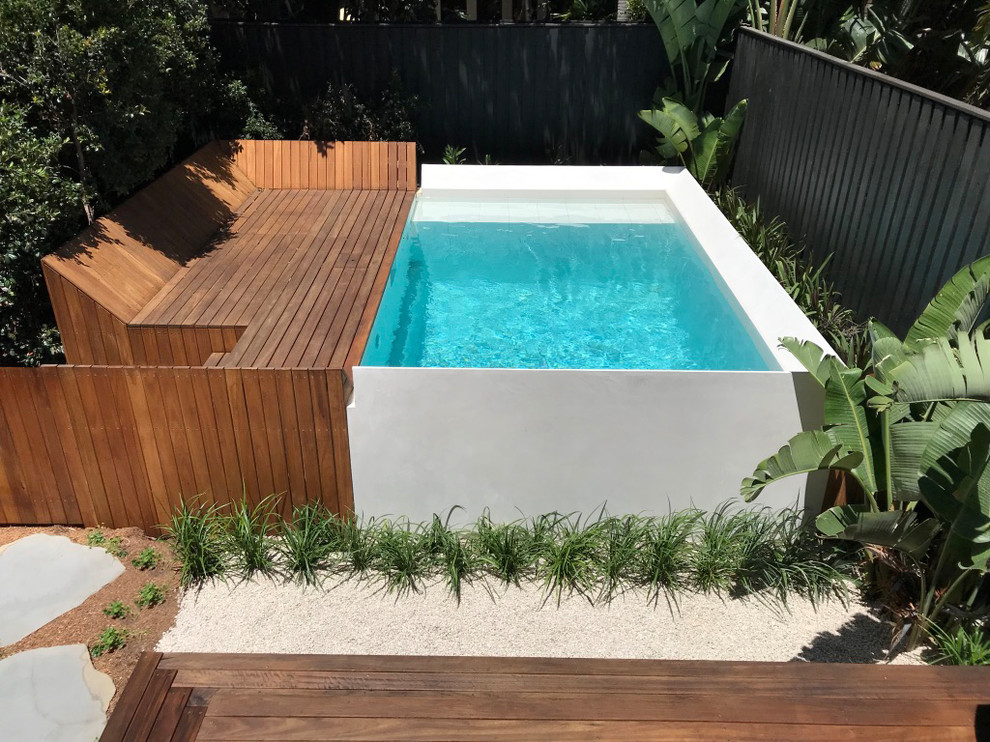На фото: наземный, прямоугольный бассейн среднего размера на заднем дворе в современном стиле с