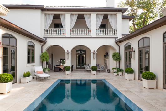 Modelo de piscina con fuente infinita mediterránea de tamaño medio rectangular en patio trasero con adoquines de hormigón