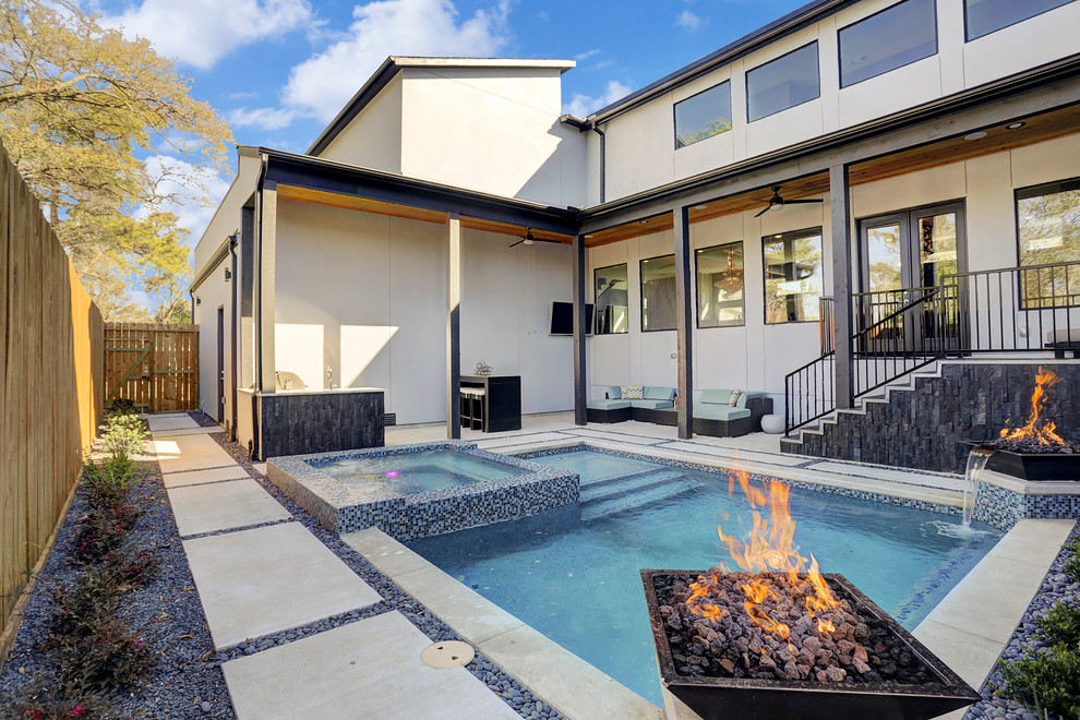 Immagine di una piscina naturale minimal personalizzata di medie dimensioni e dietro casa con fontane e pavimentazioni in cemento