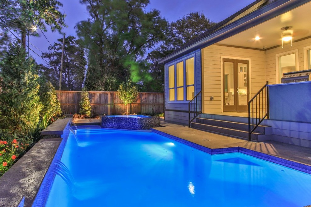 Foto de piscinas y jacuzzis naturales clásicos renovados de tamaño medio rectangulares en patio trasero con adoquines de hormigón