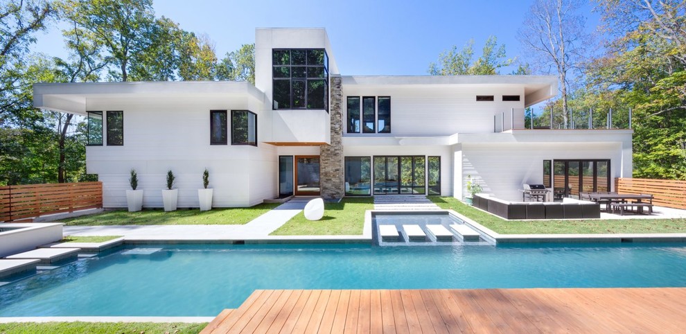 Inspiration pour une piscine arrière minimaliste rectangle avec une terrasse en bois.