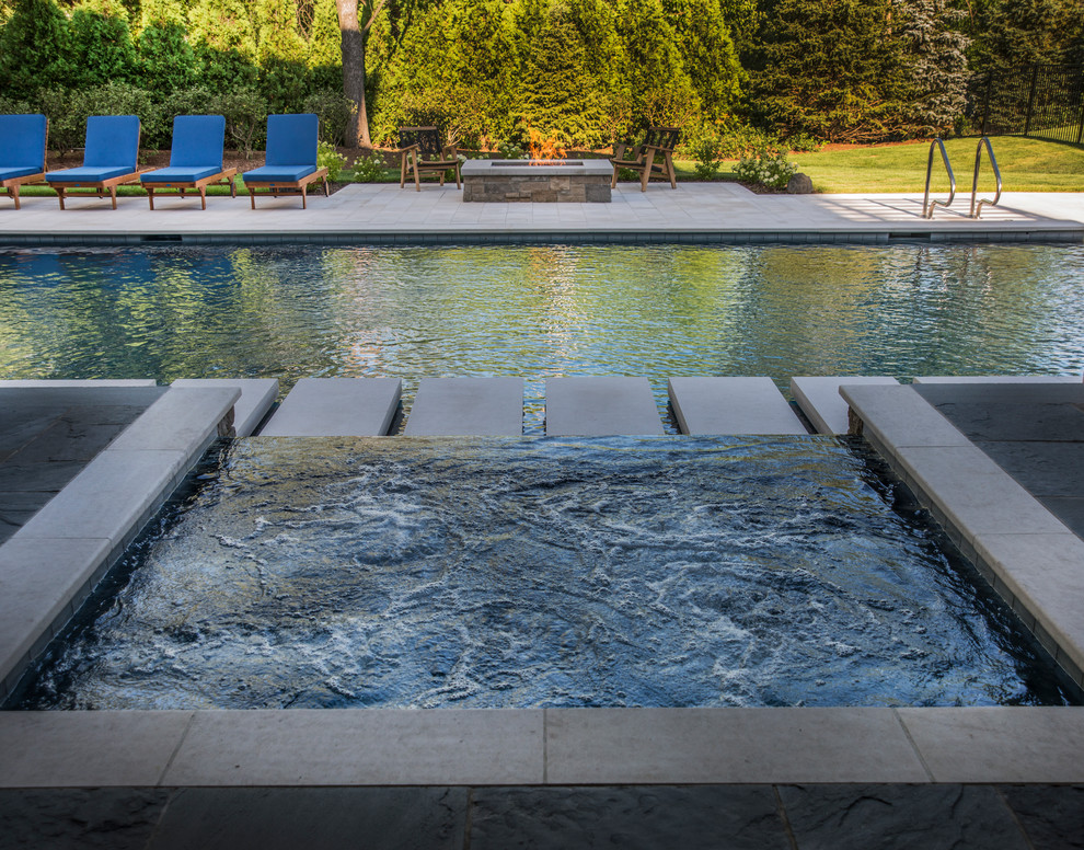 Imagen de piscinas y jacuzzis infinitos contemporáneos de tamaño medio rectangulares en patio trasero con adoquines de piedra natural