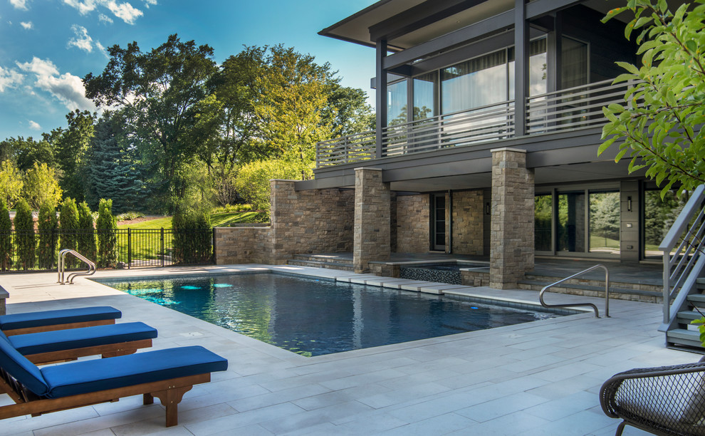 Mid-sized trendy backyard stone and rectangular infinity hot tub photo in Chicago