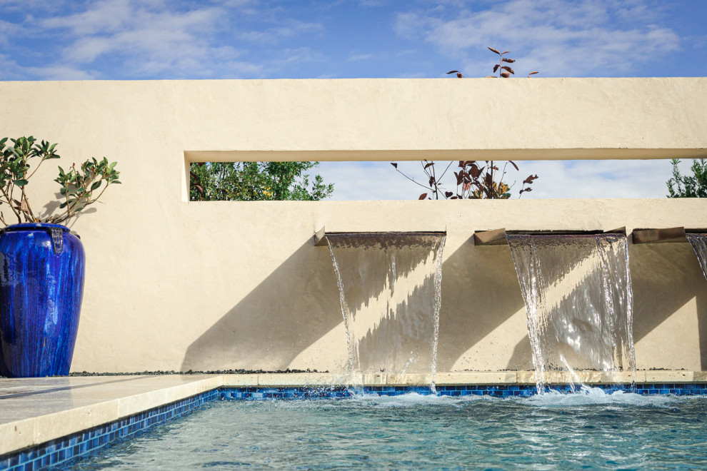 Exemple d'une grande piscine arrière chic rectangle avec des pavés en pierre naturelle.