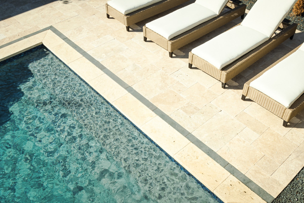 Ejemplo de piscina clásica renovada grande rectangular en patio trasero con adoquines de piedra natural