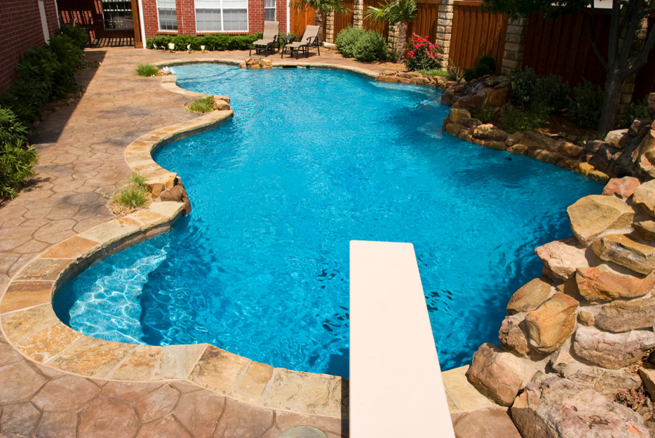 На фото: естественный бассейн среднего размера, произвольной формы на заднем дворе в классическом стиле с покрытием из каменной брусчатки