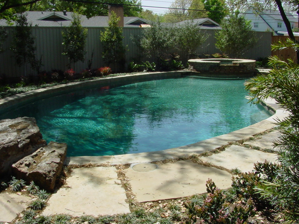 Diseño de piscina natural tradicional de tamaño medio a medida en patio trasero con adoquines de piedra natural