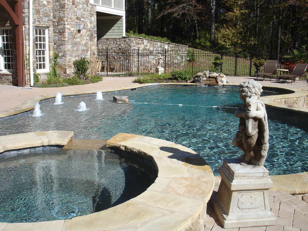 На фото: большой бассейн произвольной формы на заднем дворе в средиземноморском стиле с джакузи и мощением клинкерной брусчаткой