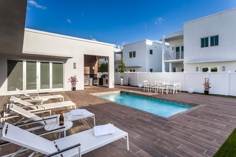 Photo of a contemporary back rectangular swimming pool in Miami with decking.